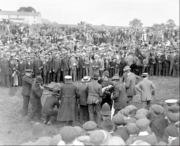 Black and white. People gathering around Emily Davison on the racecourse in 1918